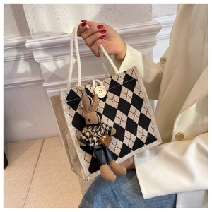 Close-up of linen tote bag with argyle pattern, rope handle, and cute bunny charm accessory