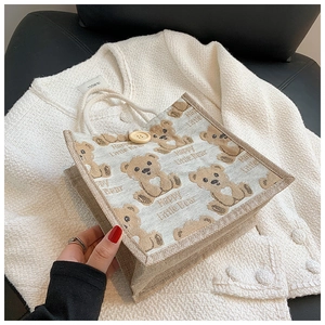 Detail of linen tote bag with printed teddy bear pattern and cotton rope handles