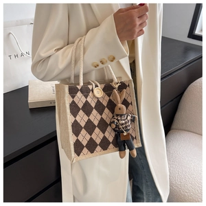Detailed view of linen tote bag with argyle pattern, woven handle and bunny charm