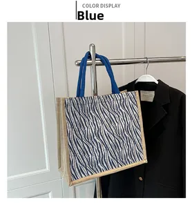 Detail of blue zebra pattern linen tote bag with braided handles on a display rack