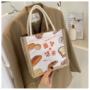 Detail of canvas tote bag with bread patterns and thick white cotton rope handles