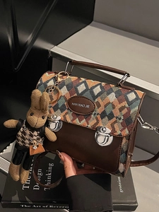Sac bandoulière vintage à carreaux avec garniture en cuir et charm lapin sur un livre