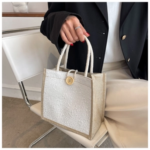 Detailed shot of a linen tote bag with lace panel, cotton rope handles and wood button