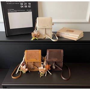 Detailed display of mini crossbody phone bags in cream, caramel, and dark brown leather