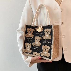 Linen tote bag with cartoon teddy bear print and cotton rope handles on white background