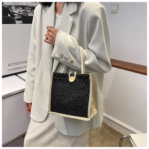 Detail of black floral linen tote bag with cream woven trim and large wooden button