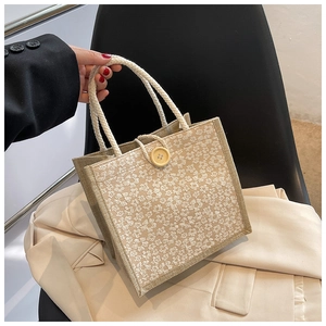 Detail of floral burlap tote bag showing jute texture and large yellow button closure