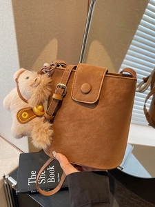 Sac seau marron avec charm de chien en peluche et fermeture magnétique à la main