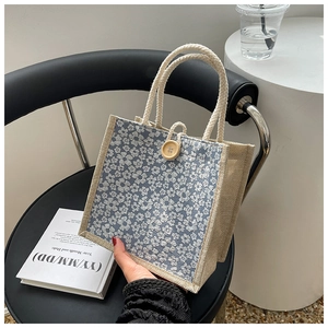 Detail of floral linen tote bag with wooden button closure and woven rope handle
