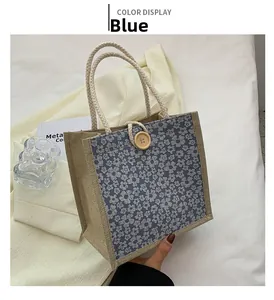 Detail of blue floral burlap tote bag with woven rope handles and round wooden button