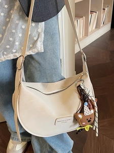 Cream white crescent dumpling shoulder bag with adjustable strap and cute bear charm
