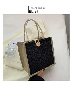 Detail of black floral linen tote bag with woven handles and wooden buckle closure