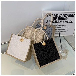 Detailed view of floral linen handbags with decorative wooden buttons and hemp rope handles