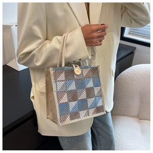 Detailed texture of blue and brown checkered canvas tote bag with thick rope handle