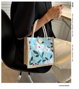 Gros plan d'un sac repas en toile fleurie avec poignées en coton et bouton en bois