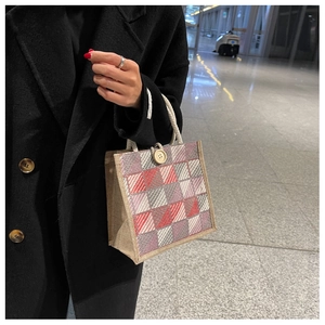 Detail of red and grey checkered tote bag with rope handle and button closure