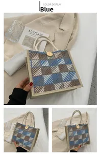 Detail of blue plaid canvas tote bag with woven handles and button closure