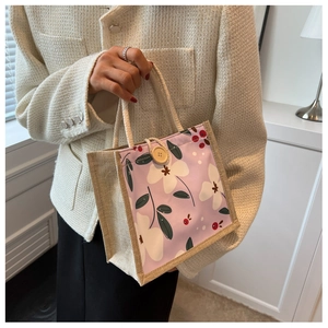 Détail du sac cabas lilas à imprimé floral avec anses tressées et bouton en bois
