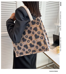 Detail view of canvas tote bag featuring heart pattern and thick cotton handles
