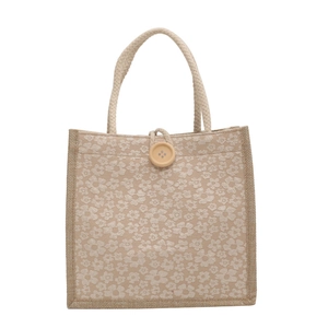 Linen tote bag with floral jacquard patterns and rustic wooden button closure