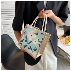Détail du sac à lunch floral avec poignées en corde de coton et grand bouton en bois