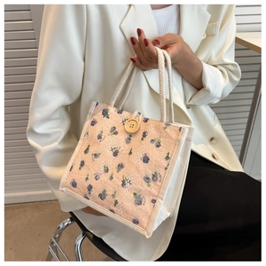 Detailed shot of floral lace lunch bag featuring cotton rope handles and wooden button