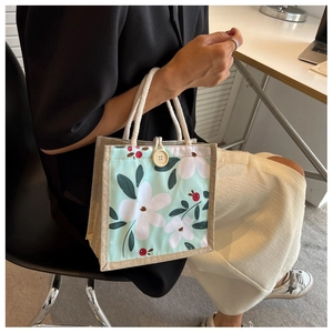 Gros plan d'un sac cabas floral en toile avec bordure en lin et bouton en bois