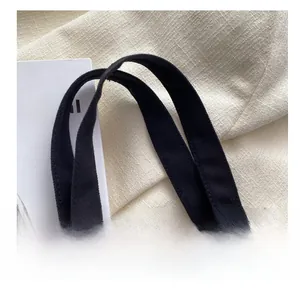 Detail of sturdy black canvas handle featuring a trendy checkered heart charm pendant