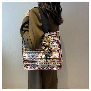 Detailed shot of ethnic canvas tote bag featuring geometric patterns and a bunny charm
