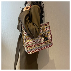 Close-up of ethnic pattern canvas tote bag with a cute rabbit doll pendant detail