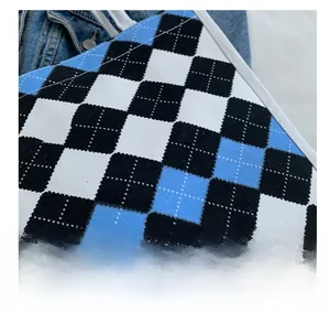 Detail of argyle knit fabric with blue pattern and durable white stitched edges