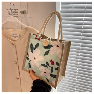 Détail du sac à lunch floral avec imprimé vert menthe, poignée en coton et bouton en bois