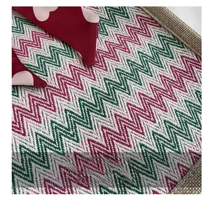 Gros plan du tissu en lin avec motifs de vagues rouges, vertes et blanches tissés