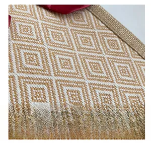 Macro detail of geometric jacquard linen fabric with golden brown braided trim