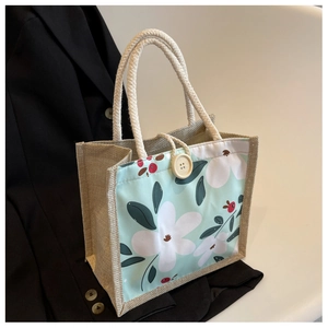 Détail du sac à lunch en toile de jute avec imprimé fleuri bleu et bouton en bois