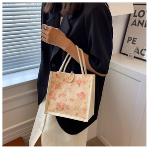 Detailed view of beige floral lace tote bag with wooden button and rope handle