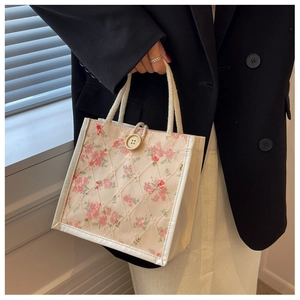 Close-up of elegant floral lace embroidery and button detail on a stylish lunch tote bag