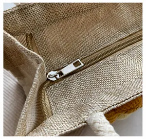 Close-up of smooth silver metal zipper on natural jute tote bag with weave texture