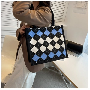 Detail shot of a knit tote bag featuring a blue, white, and black argyle pattern finish
