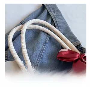 Detail showing the comfortable white woven rope handle and a polka dot decorative scarf