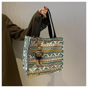 Detailed texture of ethnic canvas tote bag with colorful patterns and a bunny charm