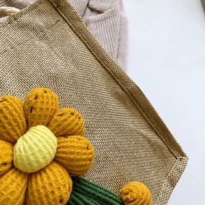 Close-up of linen handbag with decorative 3D knitted flowers and precise stitching detail