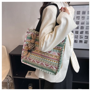 Detailed view of canvas tote featuring ethnic geometric patterns and plush bunny charm