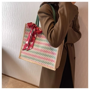 Détail du sac cabas en lin avec anse en corde verte et foulard coeur sur blazer brun