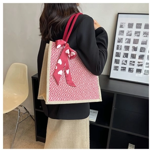 Close-up of linen tote bag featuring red geometric diamond patterns and silk scarf detail
