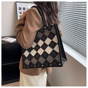 Detail of large argyle tote bag with black rope handles and spacious side profile