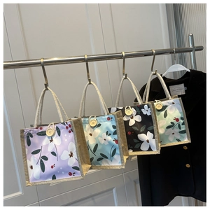 Détail de quatre sacs à lunch floraux avec poignées en coton et boutons en bois