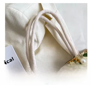 Macro shot of hemp rope handle and floral canvas fabric with pearl chain detail