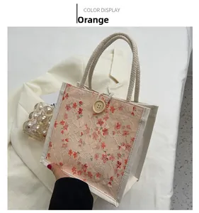 Detail of canvas mini tote bag with orange floral lace and decorative wood button