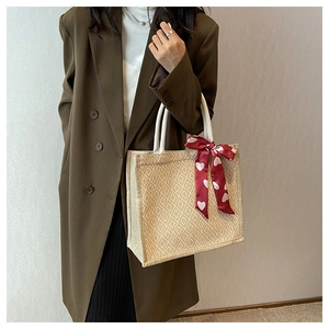 Linen tote bag with red heart scarf detail and beige geometric woven texture